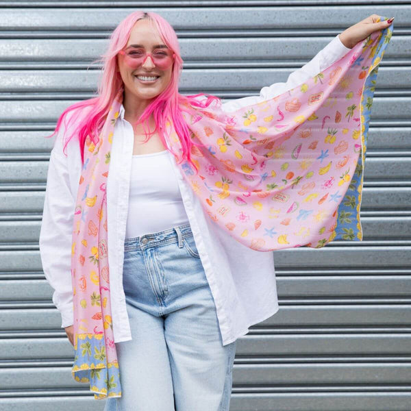 Model holding out the Sunday Picnic Modal Long Scarf to show the full pink print