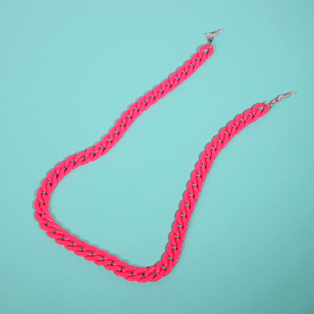 Flat lay of pink glasses chain on blue background. 