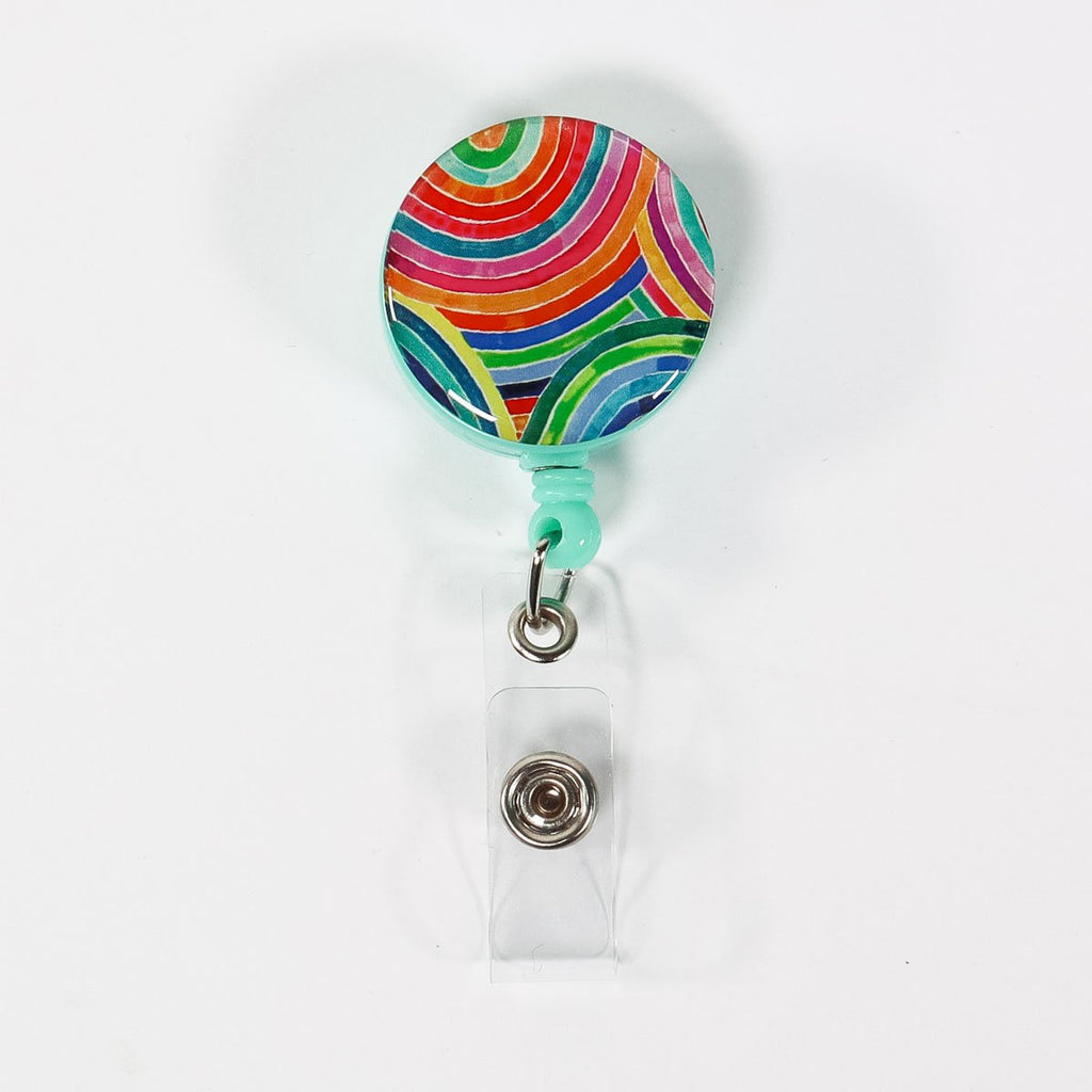 Rainbow badge reel ID holder on a white background.